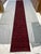 A striking long runner with a deep red field, a continuous row of navy geometric medallions, and patterned borders. Subtle...