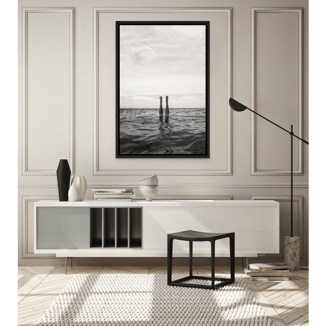 Between Breaths suspends a single human gesture between motion and stillness — legs piercing the ocean’s surface, gravity...