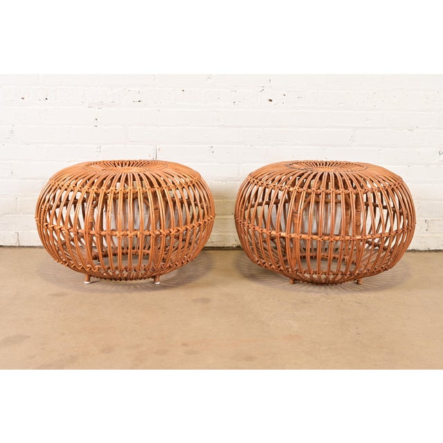 A gorgeous pair of mid-century Organic Modern bent rattan pouf ottomans, footstools, or side tables Designed by Franco...