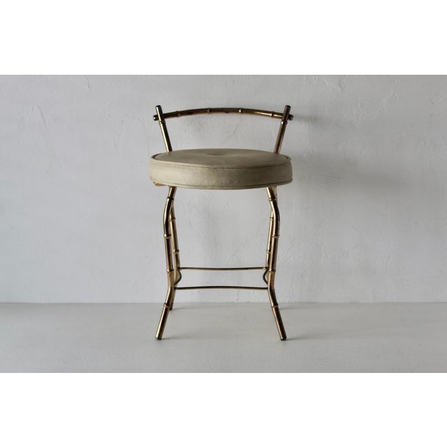Vintage George Koch gold-finish faux bamboo vanity stool featuring a round cream upholstered seat and a low open backrest....