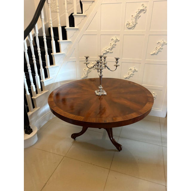 A fine antique English circular mahogany dining table dating from the Victorian period, circa 1860. The generously...