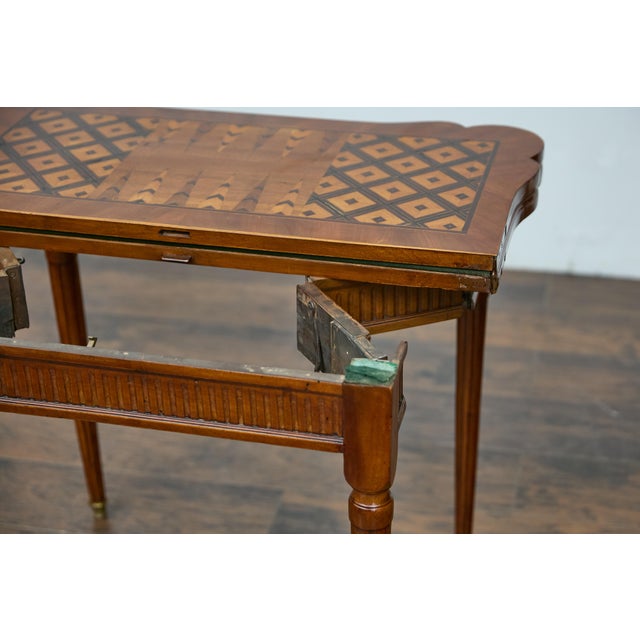 A French walnut game table from circa 1880 with marquetry and felt reversible folding top. This French walnut game table...
