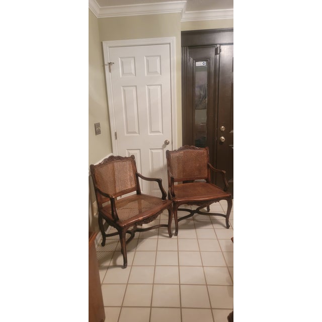 Beautiful pair of antique French Louis XV style carved armchairs crafted from walnut wood. Featuring caned seat and back...