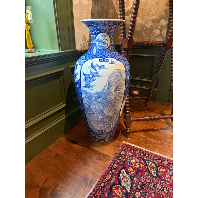 A beautiful hand painted blue and white floor vase decorated with cranes and stylized waves. This piece was made in Japan...