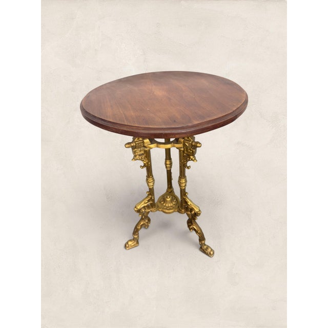 A beautiful antique French guéridon side table dating to circa 1900, featuring an ornate gilt cast iron tripod base and a...