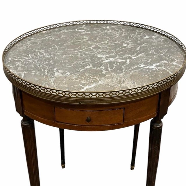 This antique French bouillotte table from the 1910s is a fine example of neoclassical design. Crafted in mahogany, it...