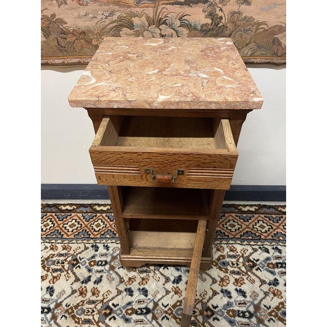 A charming French oak nightstand with loads of character. It features a shaped marble top, one drawer, and two...