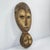 Lega masks, wooden and featuring elongated faces with a central ridge, almond-shaped eyes, and symbolic geometric...