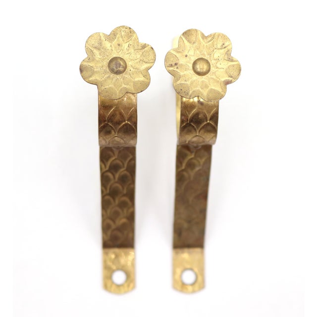 Vintage curtain rod brackets made of brass with a scalloped pattern and floral screw head. The original mounting screws...