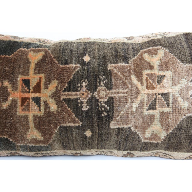 This handcrafted lumbar pillow cover is made from a vintage tribal Turkish Rug, showcasing a beautifully aged patina and...