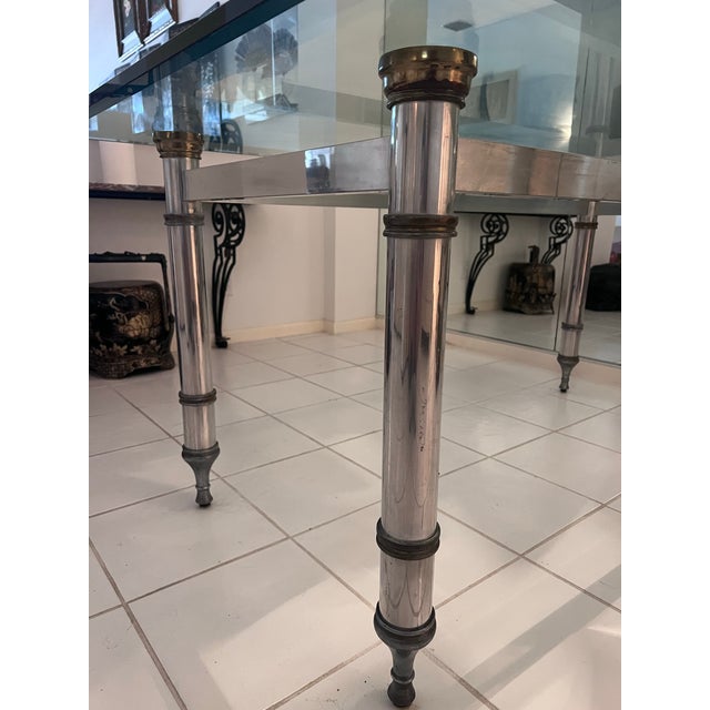 A 1960's steel and brass dining table designed by Maison Jansen. This chic, French designed dining table exudes Hollywood...