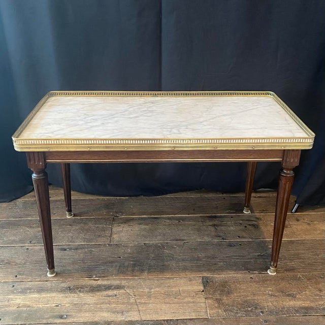 French Louis XVI mahogany & marble top coffee table, with lovely brass gallery border and elegant tapered fluted legs....