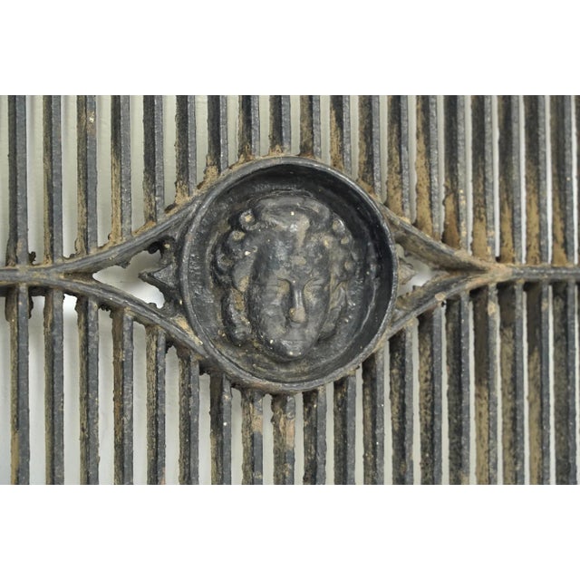 This window grate was the door to a coal shoot when coal was used to heat homes. It is cast iron and features a figural...