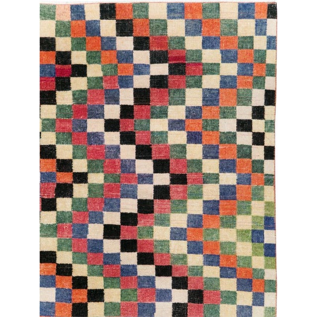 This mid-20th-century Turkish Anatolian accent rug presents a lively checkerboard composition arranged in undulating...
