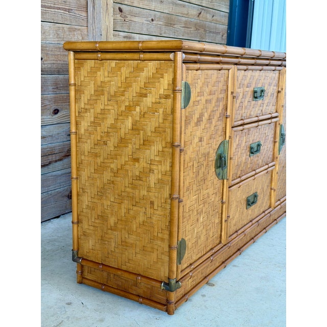 Beautiful vintage faux bamboo sideboard by Dixie featuring woven herringbone inset panels and classic campaign-style brass...
