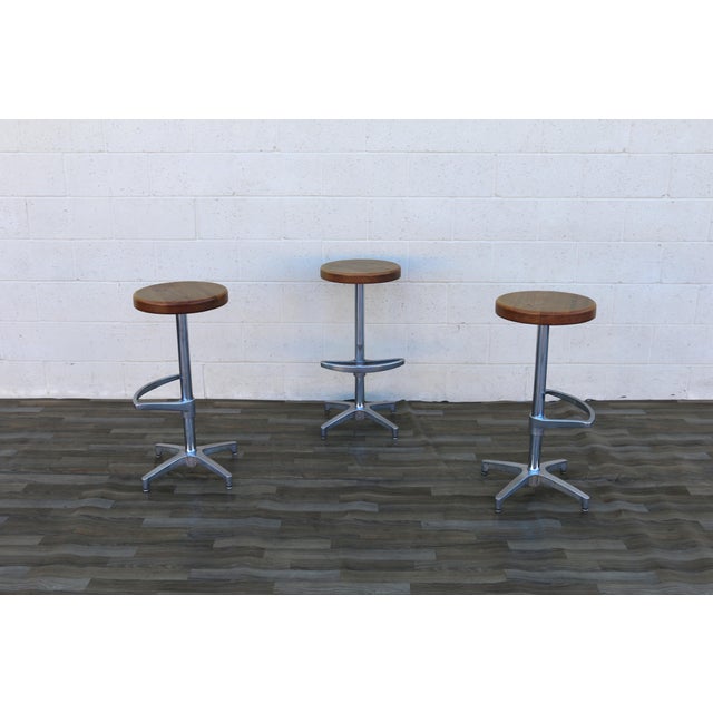 Striking set of three Mid-Century Modern swivel bar stools, crafted in the United States circa the 1970s. Combining warm...