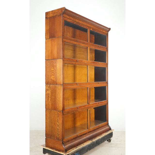 Vintage five section oak barrister bookcase in a medium toned stain. There are two panes of beveled glass and two brass...