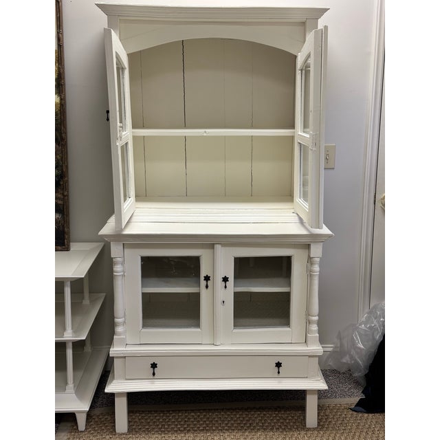 This vintage hutch cabinet has been recently finished in a fresh white while intentionally preserving the original...