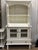 This vintage hutch cabinet has been recently finished in a fresh white while intentionally preserving the original...