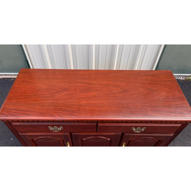 A storage buffet or sideboard made by American Furniture maker, Broyhill. A bright cherry color in a traditional...