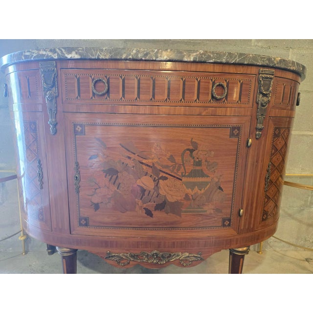 Elegant French Louis XVI–style demilune cabinet, early 20th century, featuring finely figured walnut veneers with...