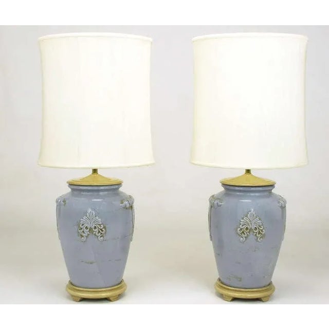 Pair of periwinkle blue ceramic vase or urn form table lamps with Vintage glaze. Cap and base are carved and lacquered...
