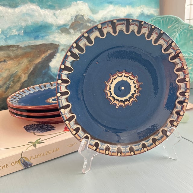 Set of four Bulgarian Troyan Redware art pottery decorative ceramic plates featuring a striking feathered marbling pattern...