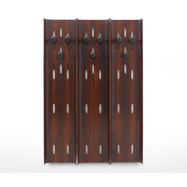 Wall-mounted coat rack in curved plywood, produced in the 1960s. The three vertical panels feature an elegant wavy profile...