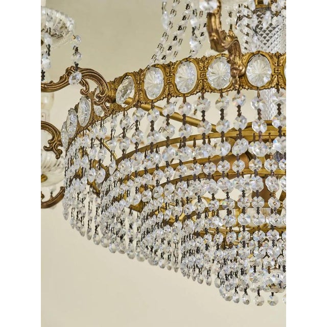 This magnificent crystal chandelier is a work of classic craftsmanship and elegance. Its elaborate bronze-tone brass...