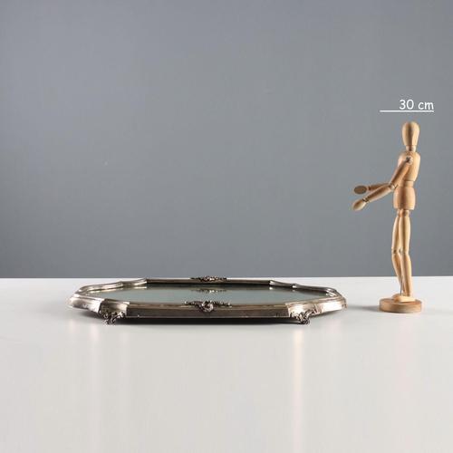 A curved-edge tray in embossed and chased silver with relief decorations and leaf-shaped scrollwork feet. Engraved silver...