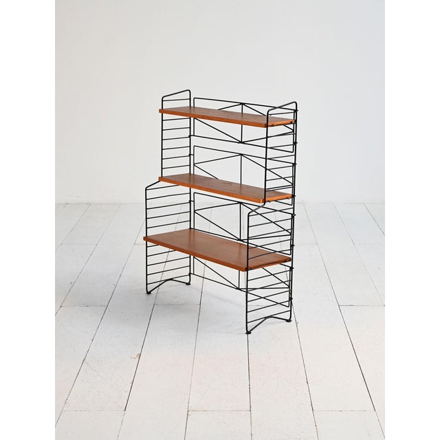 Freestanding bookcase with black-painted iron frame and adjustable teak shelves. Scandinavia, 1960s. A modular shelving...