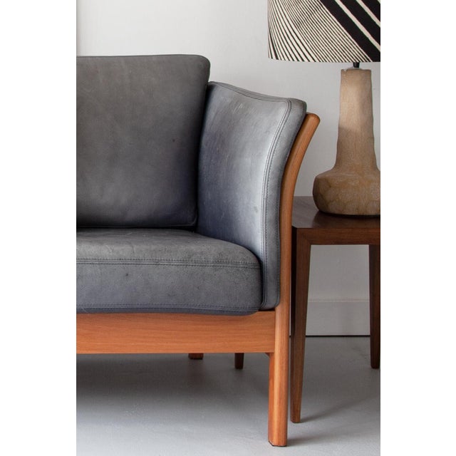 An elegant, grey leather three-seater sofa manufactured by Mogens Hansen, Stouby with a pleasing beech frame and quality...