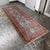 Design Plus Gallery presents a 3ft 4in × 10ft 4in Vintage Kazak Tribal Runner Rug. It has a blue field and an intricate...
