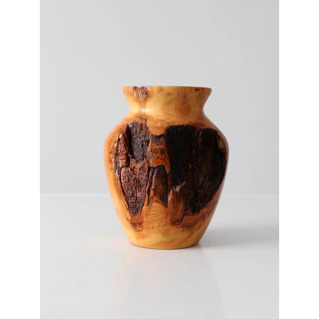 This vintage handmade burl wood vase showcases a striking contrast between its smooth, polished surface and the deep,...