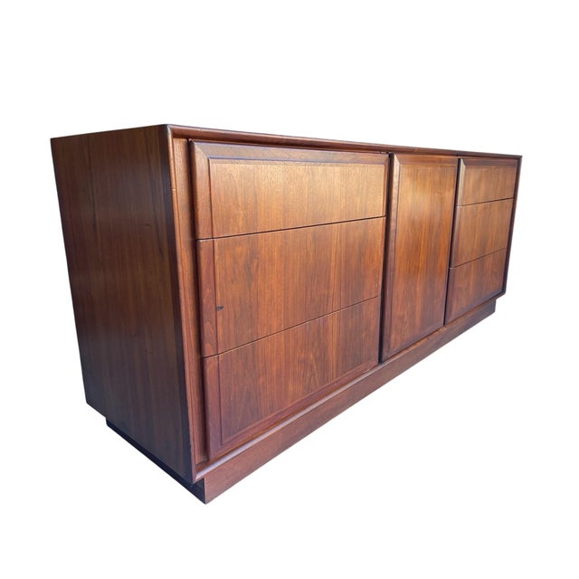 A beautifully proportioned walnut nine-drawer credenza attributed to Dillingham Manufacturing Company, date-stamped...