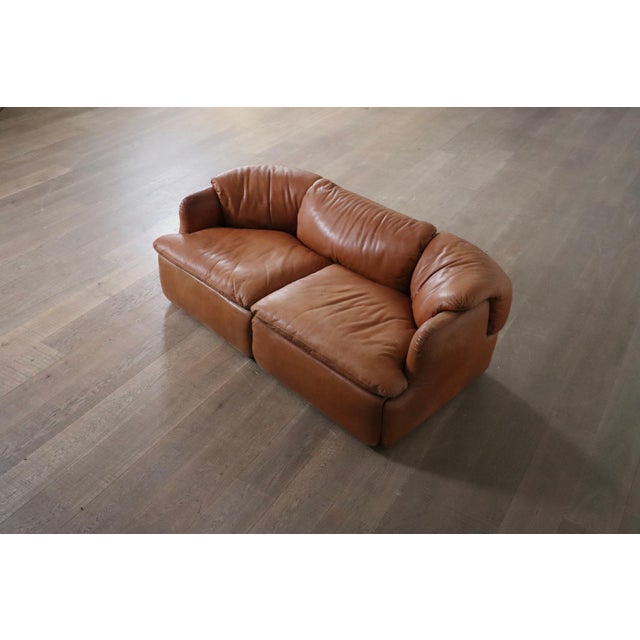 Stunning Confidential two seater sofas in original cognac leather, crafted by renowned Italian architect and furniture...