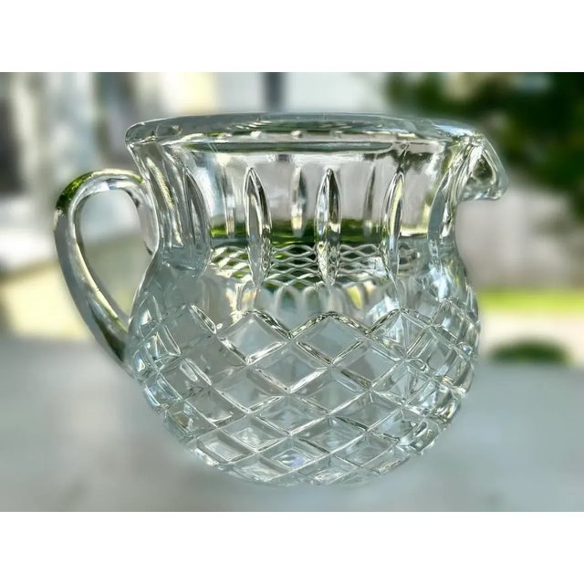 Heavy lead crystal pitcher featuring a basket weave diamond cut pattern around the pitcher and vertical cut lines above...