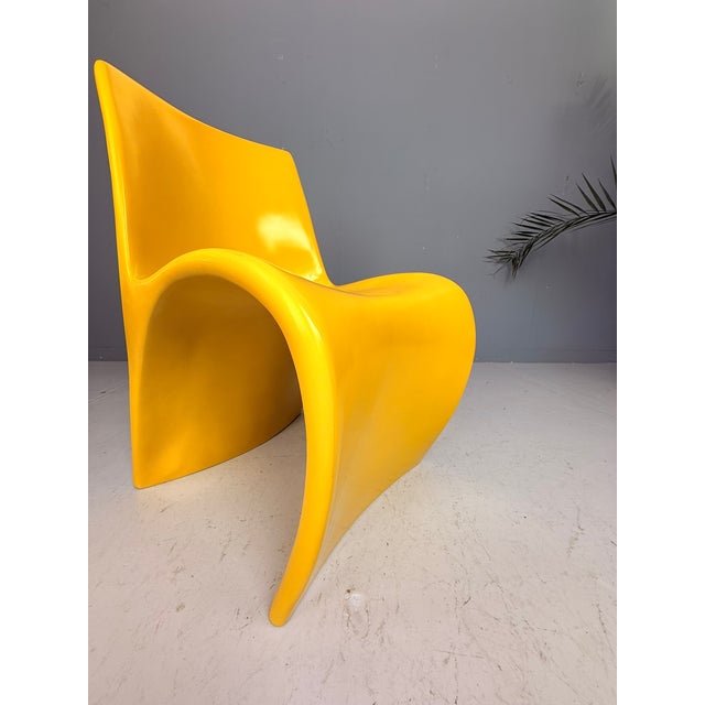 A striking sculptural chair from the 1970s, executed in molded fiberglass and finished in a vibrant yellow lacquer. The...