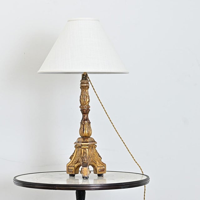 A magnificent Italian giltwood altar candlestick from the 19th century, recently electrified as a table lamp to bring that...