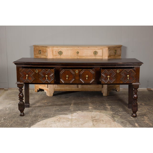 An English oak sideboard from the 19th century with geometric front and turned baluster legs. Enthrall your living space...