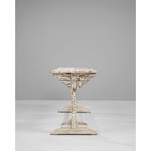 This 1900s French wood table boasts a beautifully worn, white patinated finish that reveals layers of history through its...