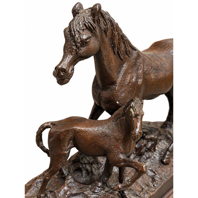 Elegant vintage equestrian table lamp featuring a detailed bronze-tone sculpture of a mare and foal on a dark wooden base....