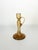An elegant amber blown-glass candleholder, featuring fine bubbles suspended within the material. Its slender silhouette,...