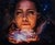 The artwork features a close-up of a face illuminated by a soft, ethereal glow, with the subject cradling a radiant...