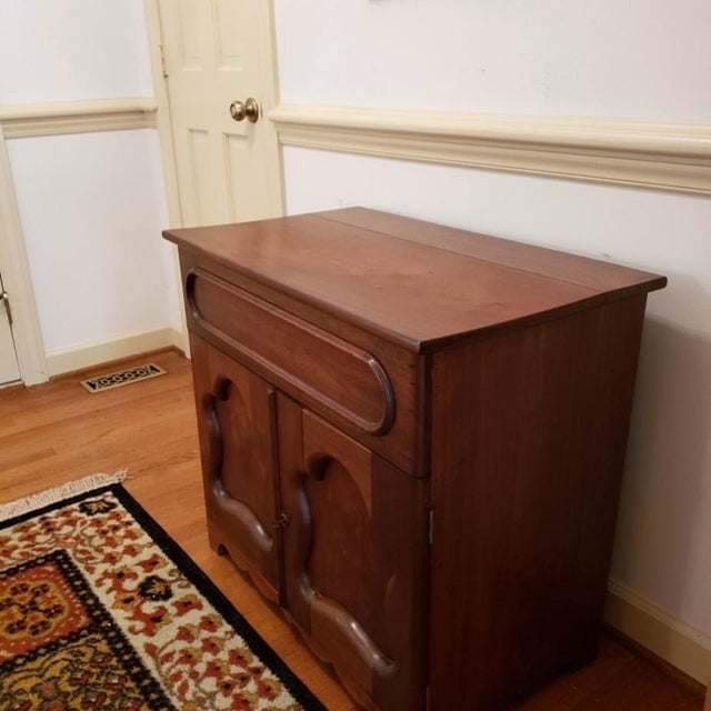 A late 19th century American dry sink cabinet, executed in warm-toned wood, possibly cherry but more likely stained...