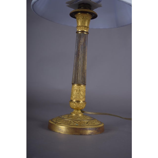 Table lamp made from a 19th-century ormolu gilt bronze candlestick, with a fluted column and ornate circular base. The...