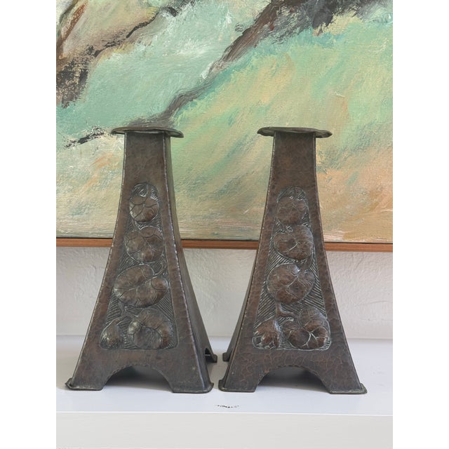 A pair of wonderful Arts & Crafts period hammered copper candle holders with a distinctive flared pyramidal form. The...