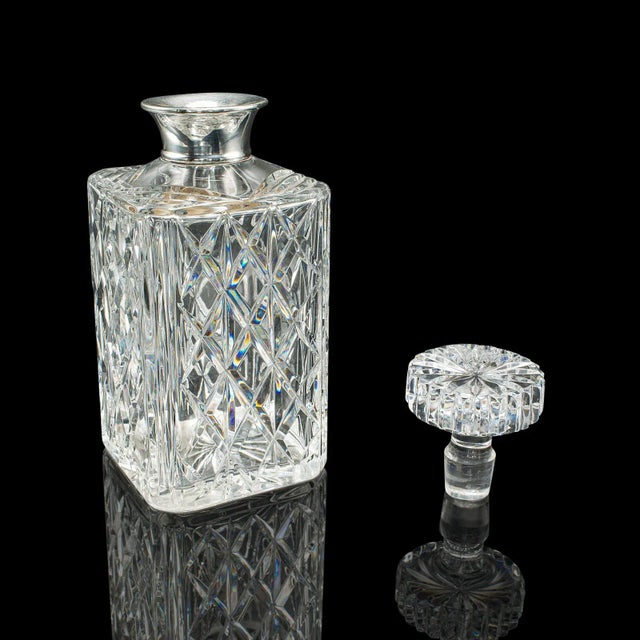 This is a fine vintage spirit decanter, crafted in England and hallmarked to 1969, offering a wonderful blend of mid-...