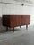 This minimalist low-profile sideboard credenza features a streamlined rectangular cabinet frame supported by elegant...