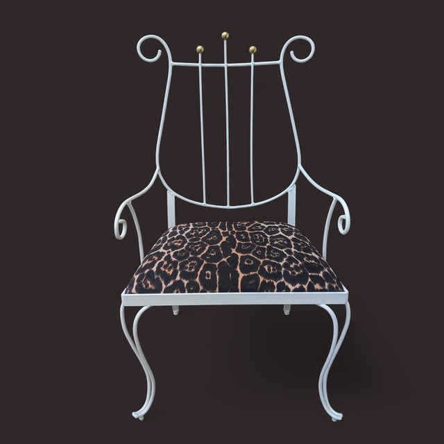 This Neoclassical Regency White Metal Arm Chair with Brass Accents, has a back that's shaped like a Lyre Musical...